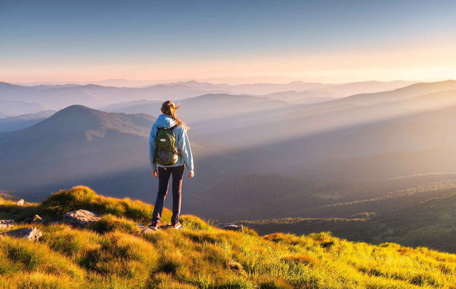 Ung person på fjelltur i soloppgang